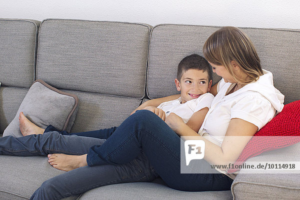 Mother and son relaxing together on sofa