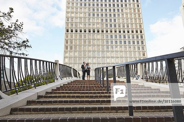 Low angle view of business people standing at top of stairway  City Hall East  Los Angeles  California  USA