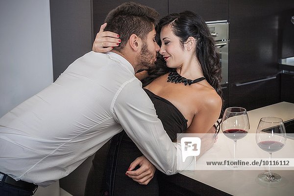 Leidenschaftliches junges Paar beim Küssen in der Küche