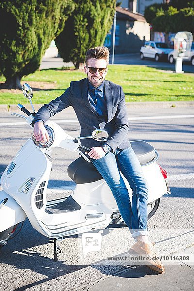 Portrait of stylish young man on moped
