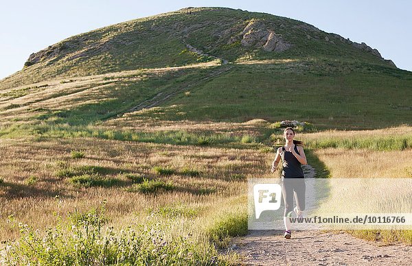 Junge Frau beim Laufen auf der Bergstrecke