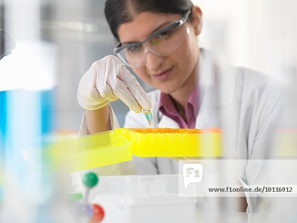 Wissenschaftlerin betrachtet chemische Probe im Labor