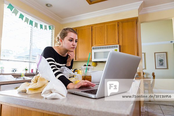 Frau mit Laptop in der Küche