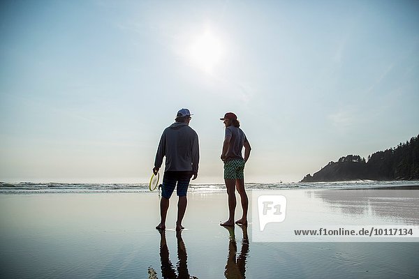 Rückansicht von zwei jungen Männern am Short Sands Beach  Oregon  USA