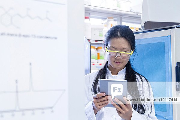 Wissenschaftlerin beim Lesen von digitalen Tabletten im Labor