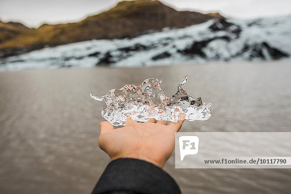 Hand der Touristin mit Eis in Solheimajokull  Island