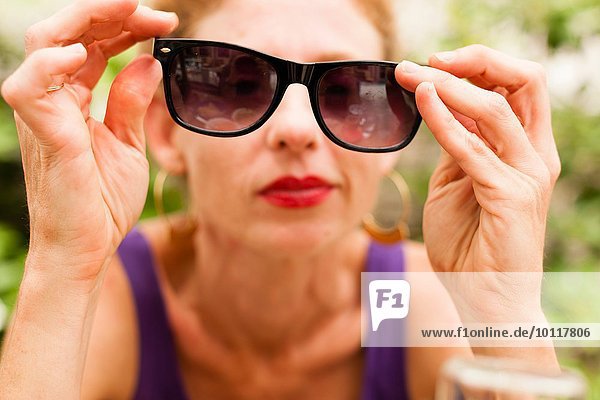 Mittlere erwachsene Frau mit Sonnenbrille vor den Augen