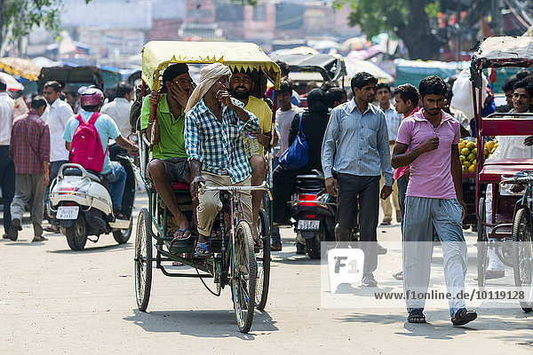 People and cycle rickshaws are moving through the streets of the suburb Old Delhi  Delhi  India  Asia