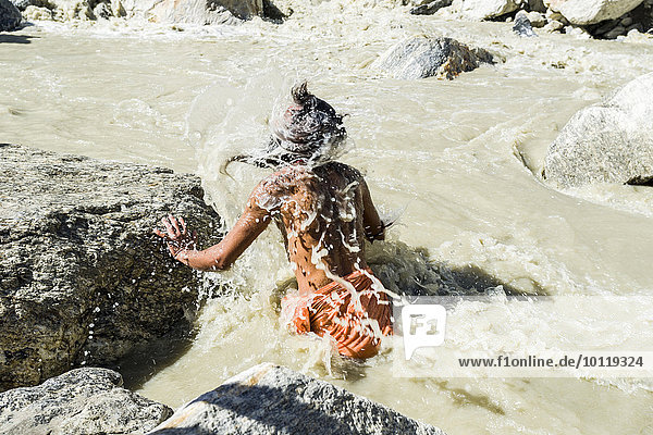 Ein Sadhu  heiliger Mann  nimmt ein Bad im eiskalten Wasser am Gaumukh  Hauptquelle des Ganges  Gangotri  Uttarakhand  Indien  Asien
