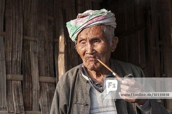 Old local man from the tribe of the Palaung smoking a pipe  portrait  near Kyaing Tong  Shan State  Golden Triangle  Myanmar  Asia