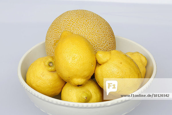 Zitronen und Cantaloupemelone in Obstschale
