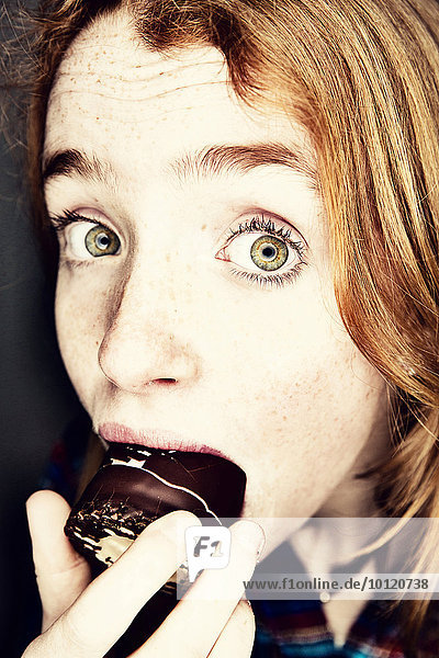 Girl eating a chocolate-coated marshmallow   Germany  Europe
