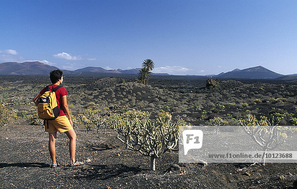 Hiking amidst the volcanic scenery by Uga  Lanzarote  Canary Islands  Spain  Europe