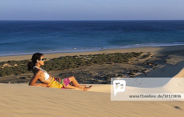 Frau liegt auf Sanddüne bei den Playas de Sotavento  Fuerteventura  Kanarische Inseln  Spanien  Europa