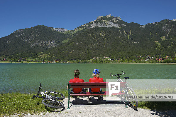 Cyclists resting on a bench on Lake Achensee  Tyrol  Austria  Europe