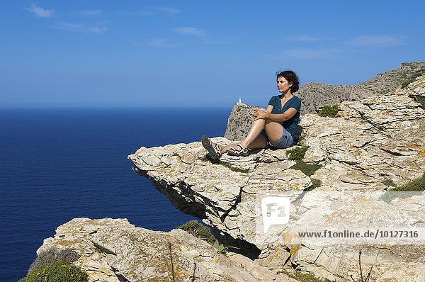Frau genießt Aussicht am Cap de Formentor  hinten der Leuchtturm  Mallorca  Balearen  Spanien  Europa