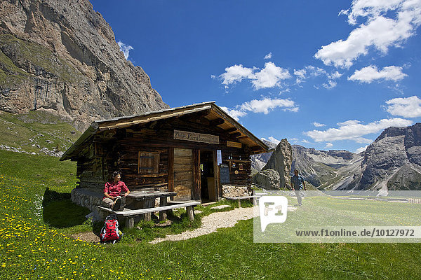 Frau macht Rast auf der Malga Alm unterhalb der Geislerspitzen  Seceda  Grödnertal  Dolomiten  Provinz Südtirol  Trentino-Südtirol  Italien  Europa