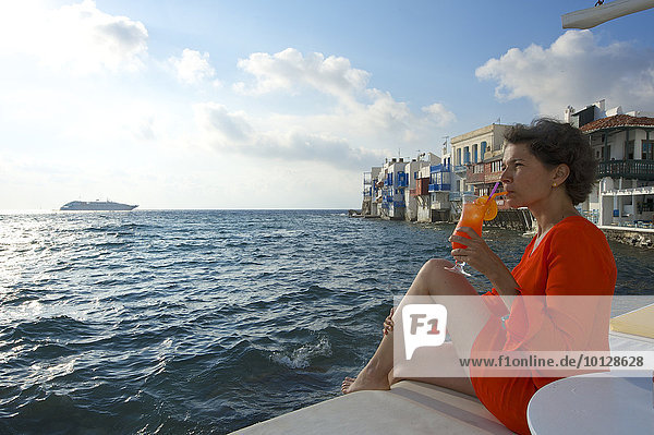 Frau genießt Cocktail und Ausblick aufs Meer  Klein-Venedig  Mykonos-Stadt  Mykonos  Kykladen  Griechenland  Europa