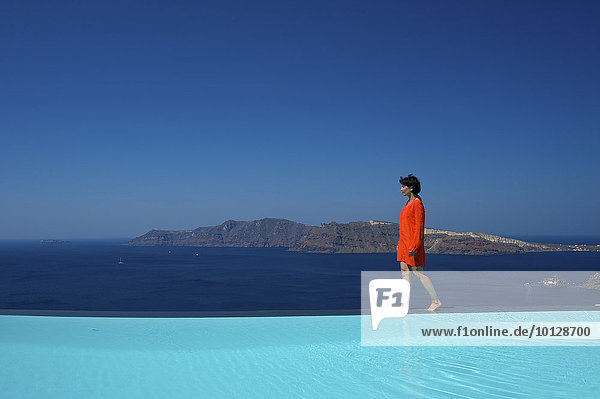 Frau geht am Pool des Hotels Perivolas entlang  Oia  Santorin  Kykladen  Griechenland  Europa