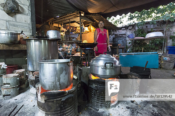 Thailänderin bereitet Essen zu  Töpfe auf offenem Feuer  traditionelles Restaurant  Provinz Kanchanaburi  Zentralthailand  Thailand  Asien