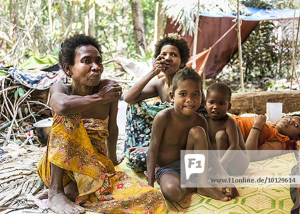 Women and children of the Orang Asil tribe sitting under tarpaulins in the jungle  native  indigenous people  tropical rain forest  Taman Negara National Park  Malaysia  Asia
