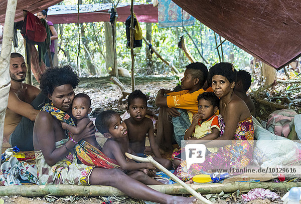 Männer Frauen und Kinder der Orang Asil sitzen unter Planen im Dschungel  Ureinwohner  indigenes Volk  tropischer Regenwald  Nationalpark Taman Negara  Malaysia  Asien