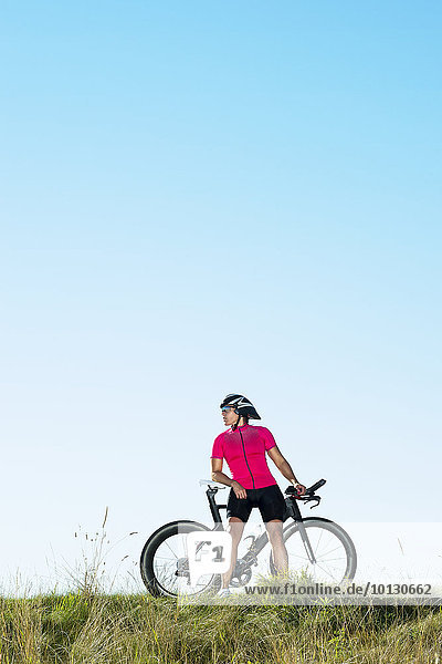 Cyclist standing with bicycle