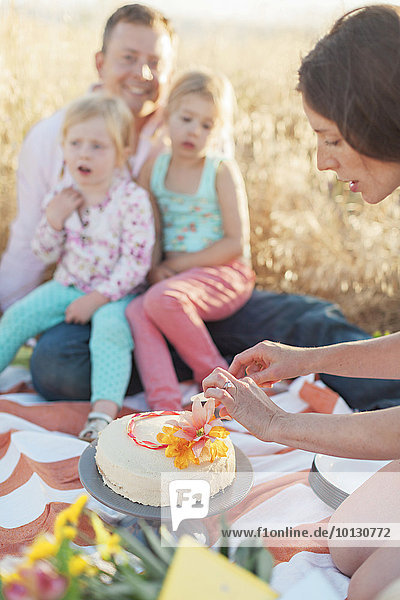 Woman cutting cake at picnic