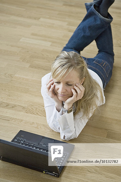Woman using laptop on floor
