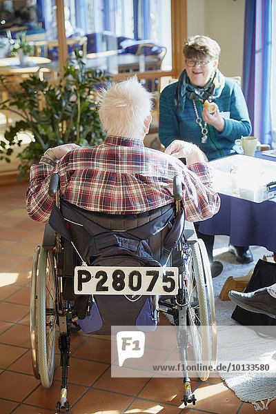 Senior man talking with nurse in care home