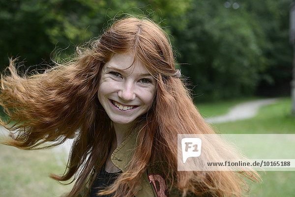 Teenage girl with long red hair  flicking her hair  Germany  Europe