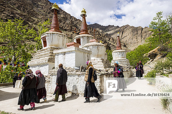Local pilgrims are walking around a Chorten in a small valley above Hemis Gompa  Hemis  Jammu and Kashmir  India  Asia