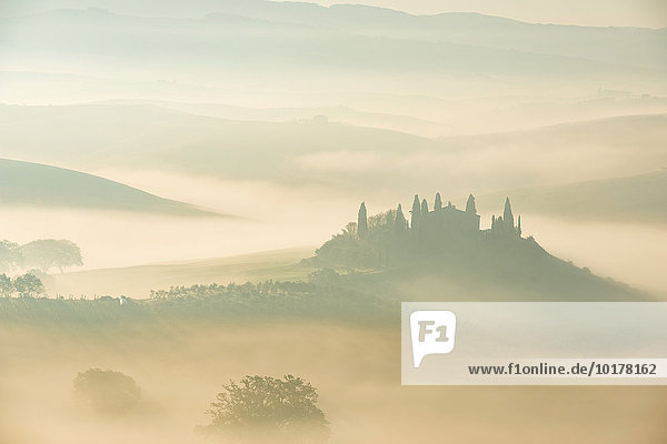 Podere Belvedere farmhouse  view of the Orcia Valley  at sunrise in the fog  San Quirico d'Orcia  Orcia Valley  Tuscany  Italy  Europe