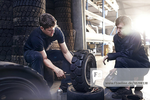 Mechaniker reparieren Reifen in der Kfz-Werkstatt