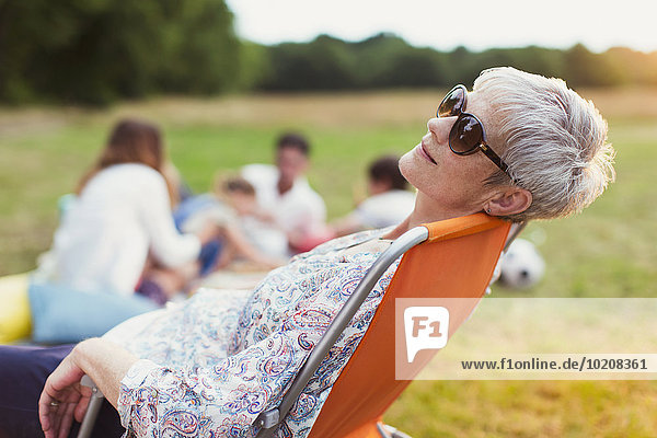 Seniorin entspannt sich im Stuhl im Feld