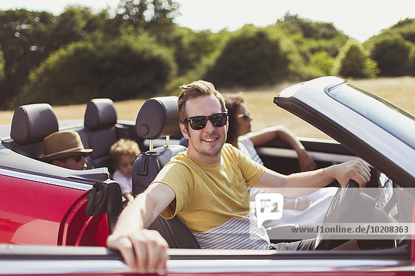 Portrait lächelnder Mann im Cabriolet mit Familie
