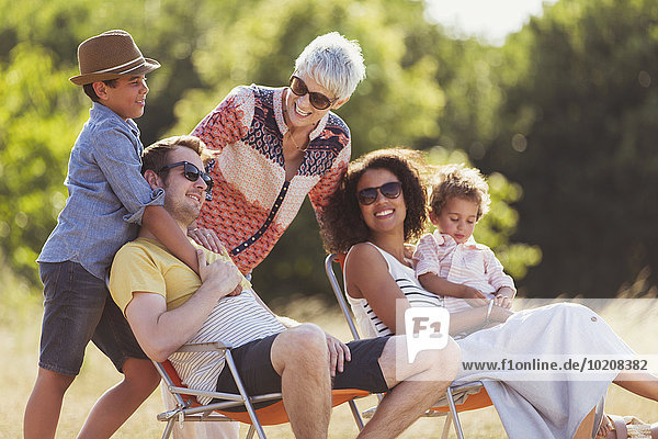 Mehrgenerationen-Familie entspannt im sonnigen Feld