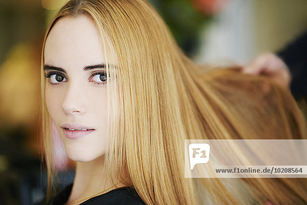 Close up portrait woman with strawberry blonde hair in salon