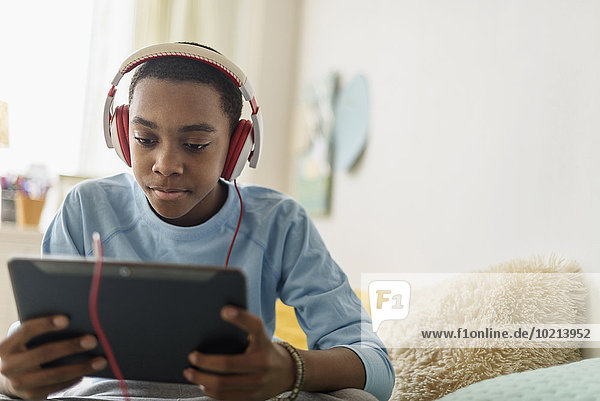 Black boy in headphones using digital tablet