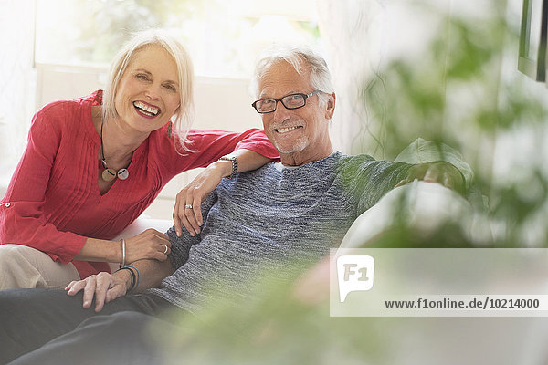 Older Caucasian couple smiling in living room