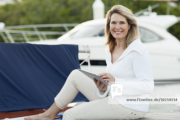 Caucasian woman using digital tablet on boat deck