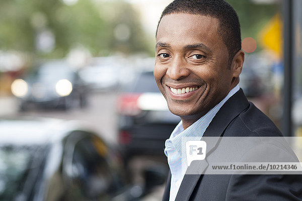 Black businessman smiling in city