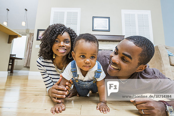 Black family playing on living room floor