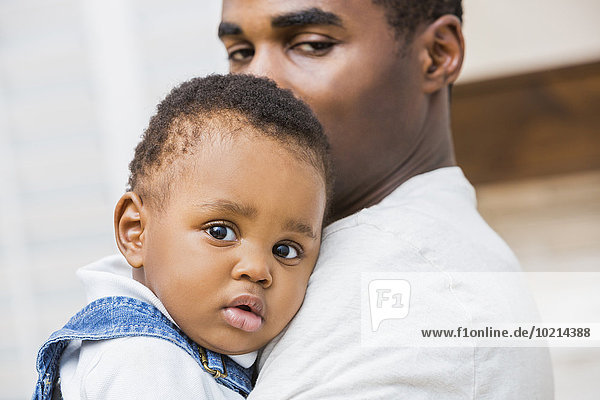 Close up of Black father holding baby son