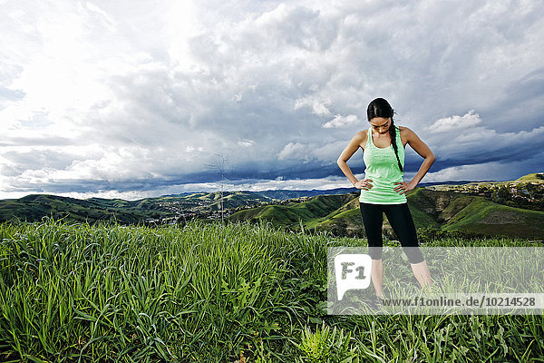 Mixed race athlete standing on rural hilltop