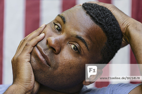 Close up of concerned Black man in front of American flag