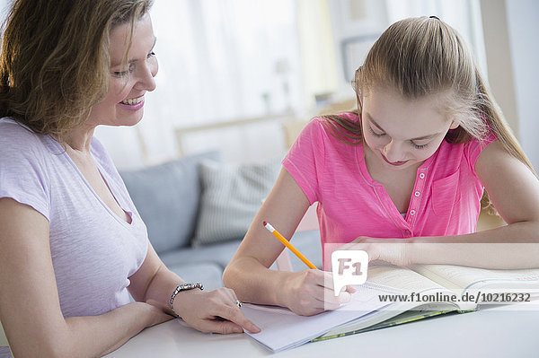 Caucasian mother helping daughter with homework