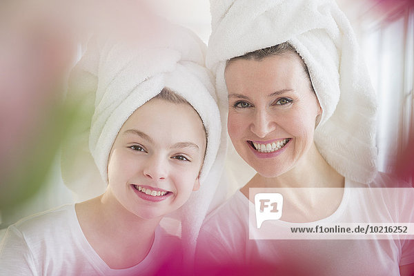 Caucasian mother and daughter wearing towels in hair