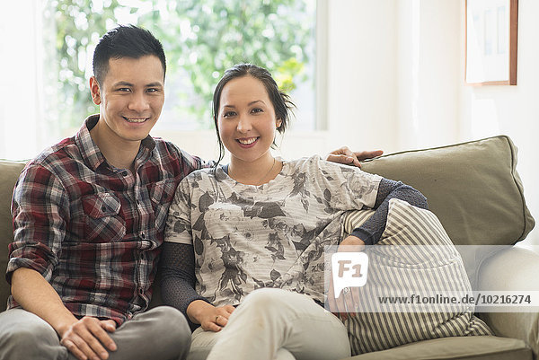 Couple smiling on sofa in living room