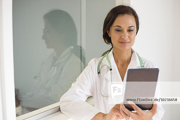 Mixed race doctor using digital tablet